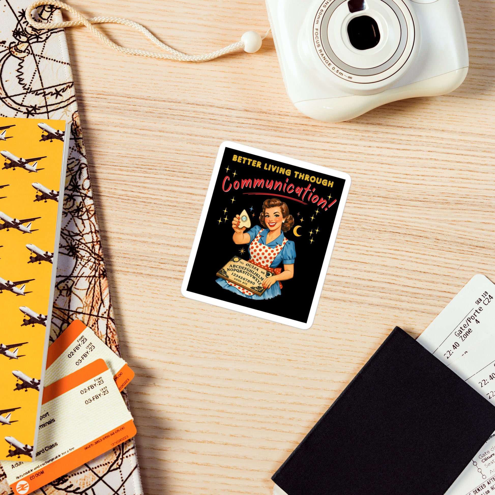 Better Living Through Communication vinyl decal on refrigerator — vintage 1950s retro housewife in polka dot apron holding ouija board and planchette on black background, satin finish waterproof sticker by Cinderpoint Studios