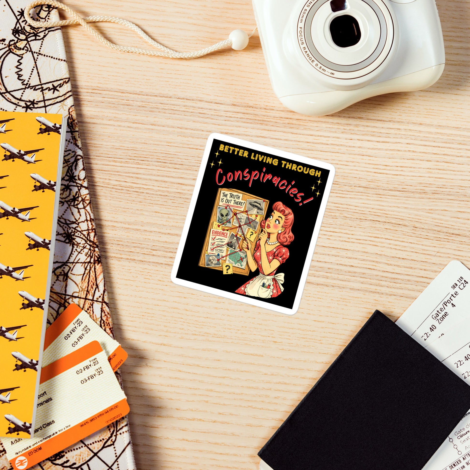 Better Living Through Conspiracies vinyl decal — vintage 1950s retro housewife pointing at alien evidence cork board with red string and UFO photos on black background, satin finish waterproof sticker by Cinderpoint Studios