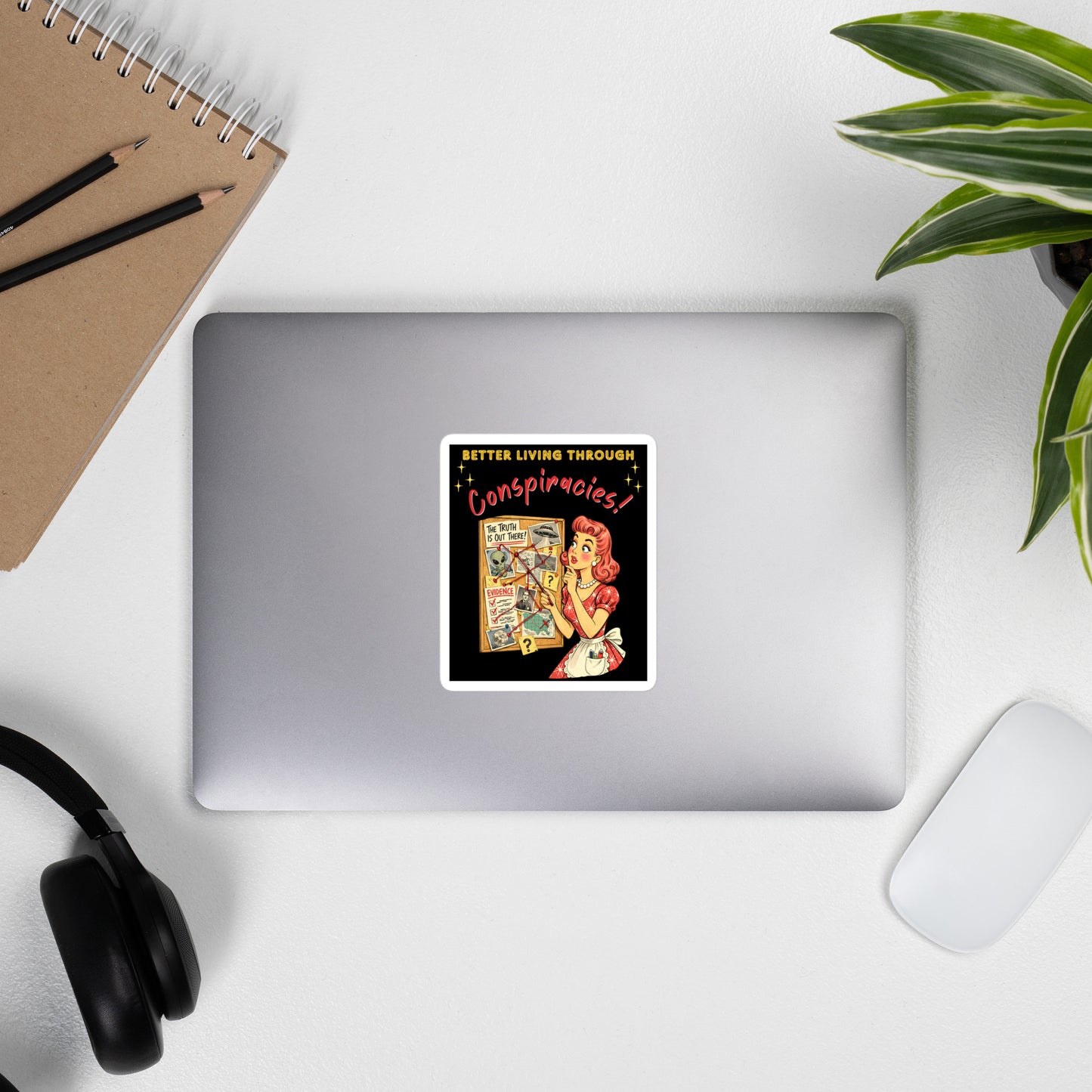 Better Living Through Conspiracies vinyl decal — vintage 1950s retro housewife pointing at alien evidence cork board with red string and UFO photos on black background, satin finish waterproof sticker by Cinderpoint Studios