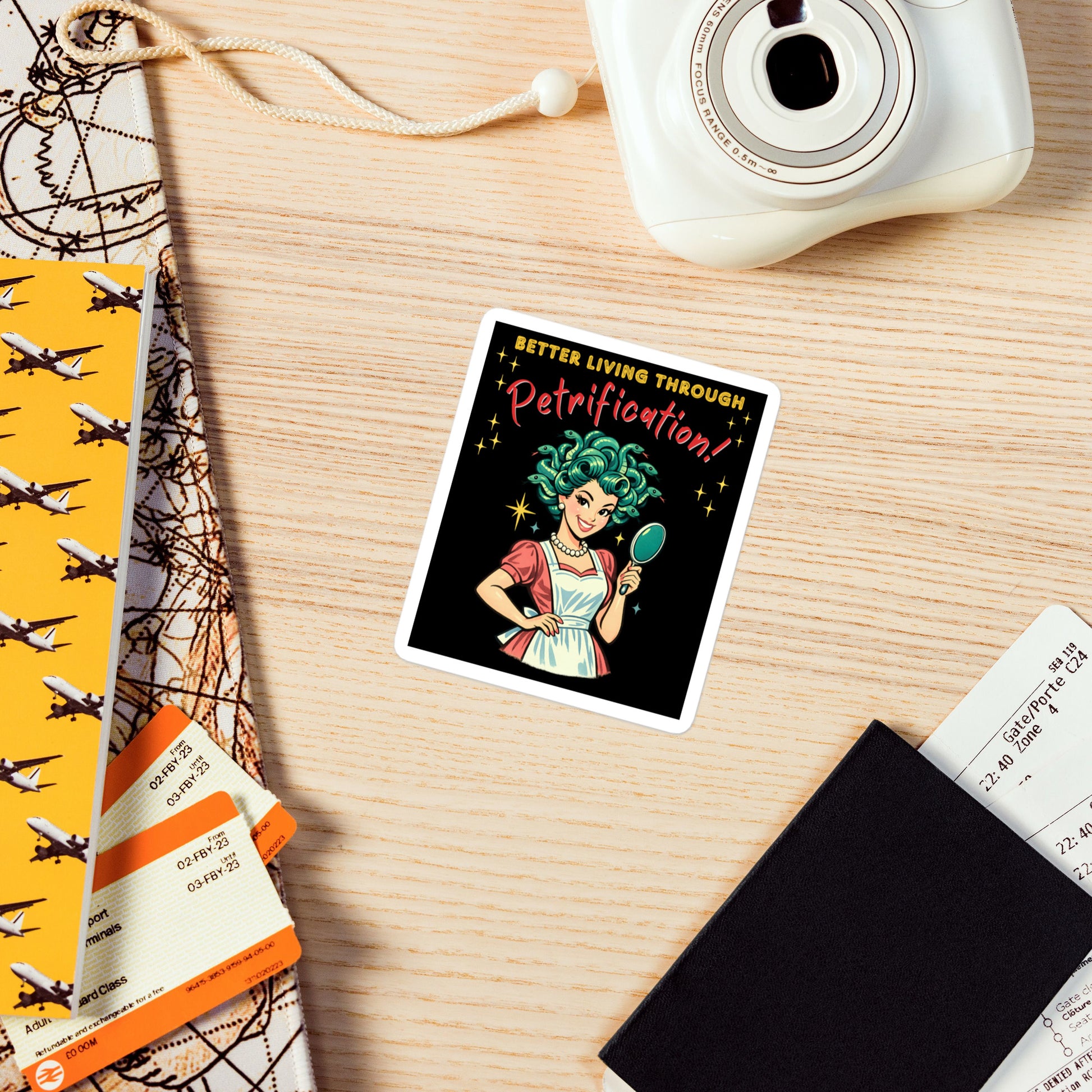 Better Living Through Petrification vinyl decal — vintage 1950s retro Medusa housewife with styled snake hair holding a hand mirror and smiling confidently in pearls and apron on black background, satin finish waterproof sticker by Cinderpoint Studios