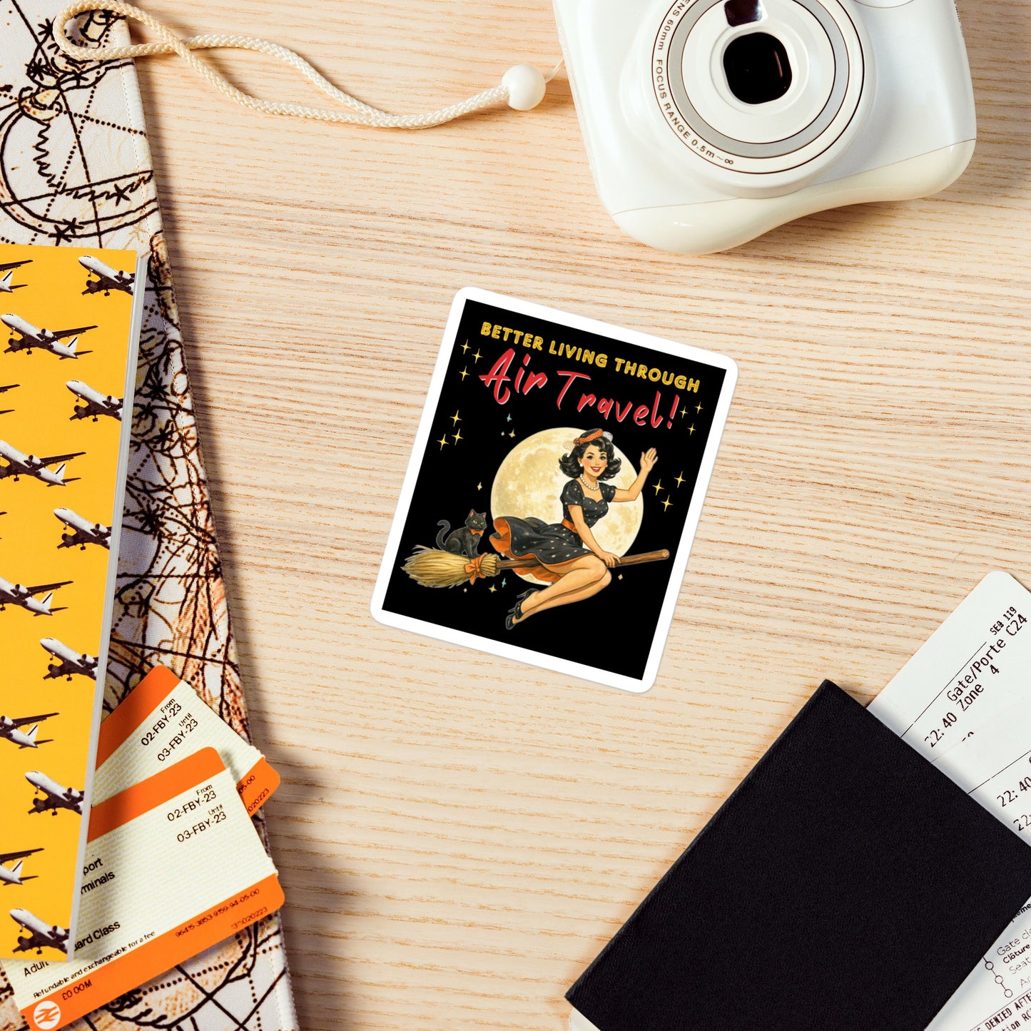 Better Living Through Air Travel vinyl decal — vintage retro pinup witch in black polka dot dress and stewardess hat riding a broom in front of a full moon with dapper black cat familiar in orange bow tie on black background, satin finish waterproof sticker by Cinderpoint Studios
