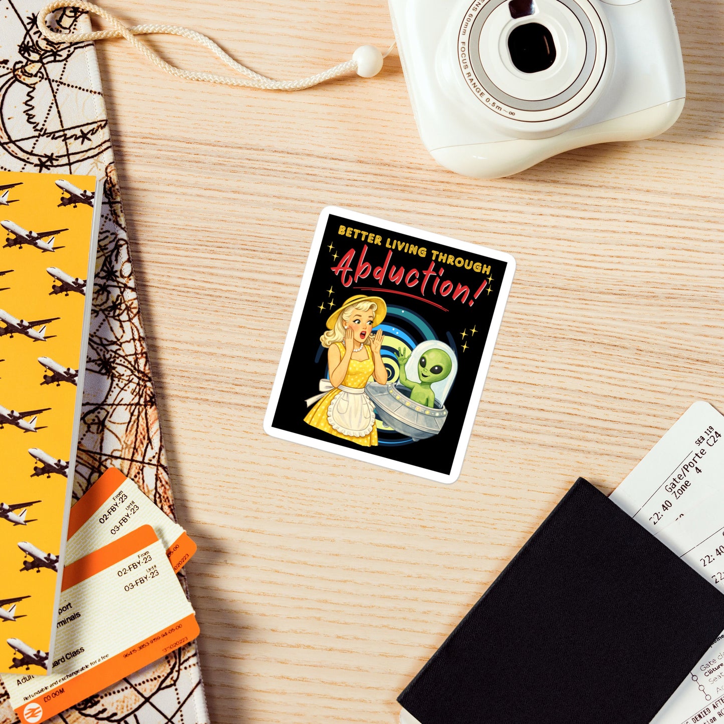 Better Living Through Abduction vinyl decal — vintage 1950s retro blonde housewife in yellow polka dot dress reacting with delight to a friendly green alien waving from a silver saucer on black background, satin finish waterproof sticker by Cinderpoint Studios
