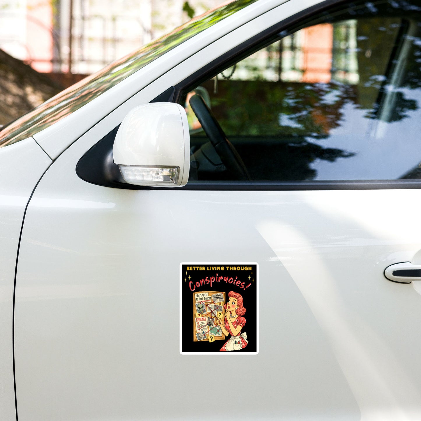Better Living Through Conspiracies vinyl decal — vintage 1950s retro housewife pointing at alien evidence cork board with red string and UFO photos on black background, satin finish waterproof sticker by Cinderpoint Studios