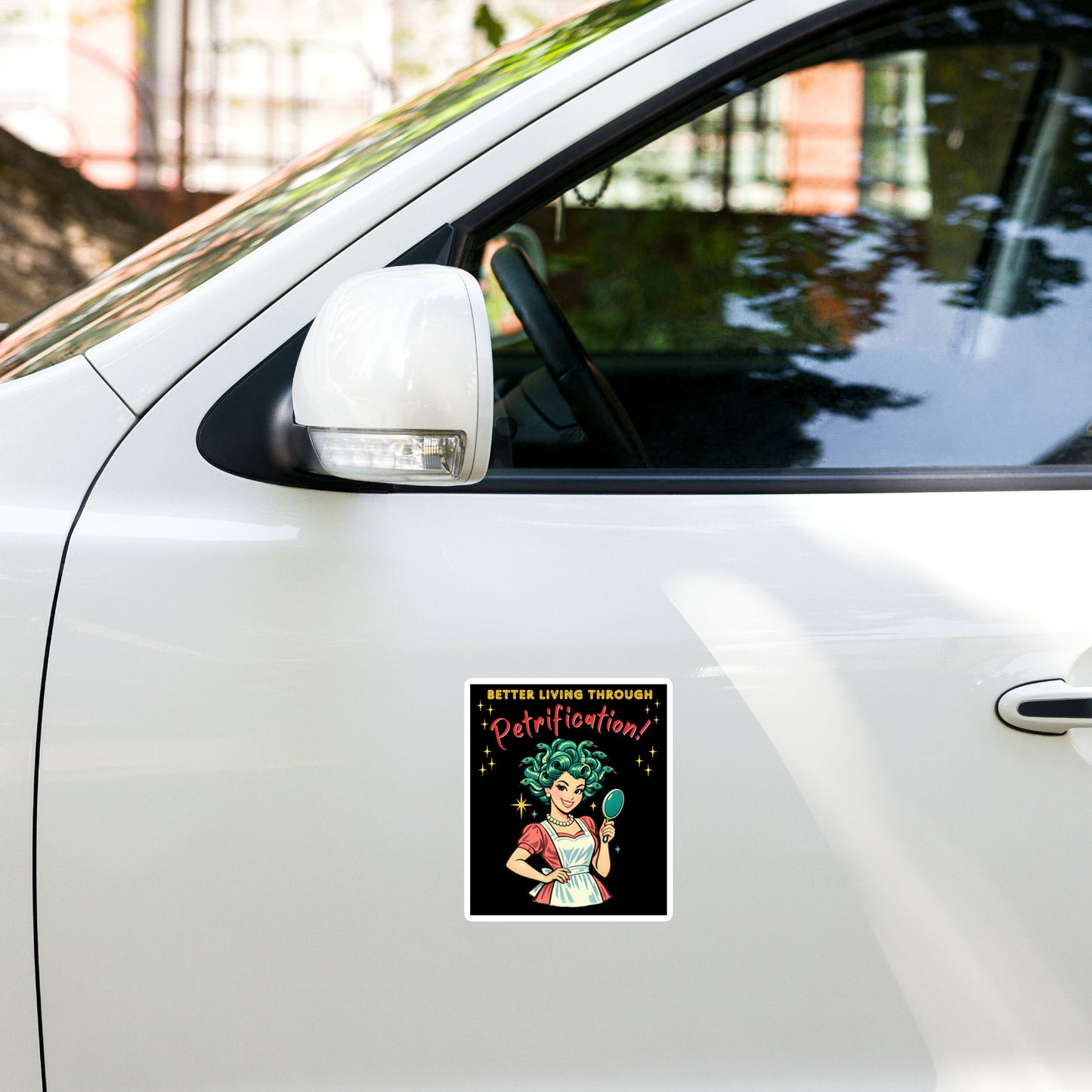 Better Living Through Petrification vinyl decal — vintage 1950s retro Medusa housewife with styled snake hair holding a hand mirror and smiling confidently in pearls and apron on black background, satin finish waterproof sticker by Cinderpoint Studios