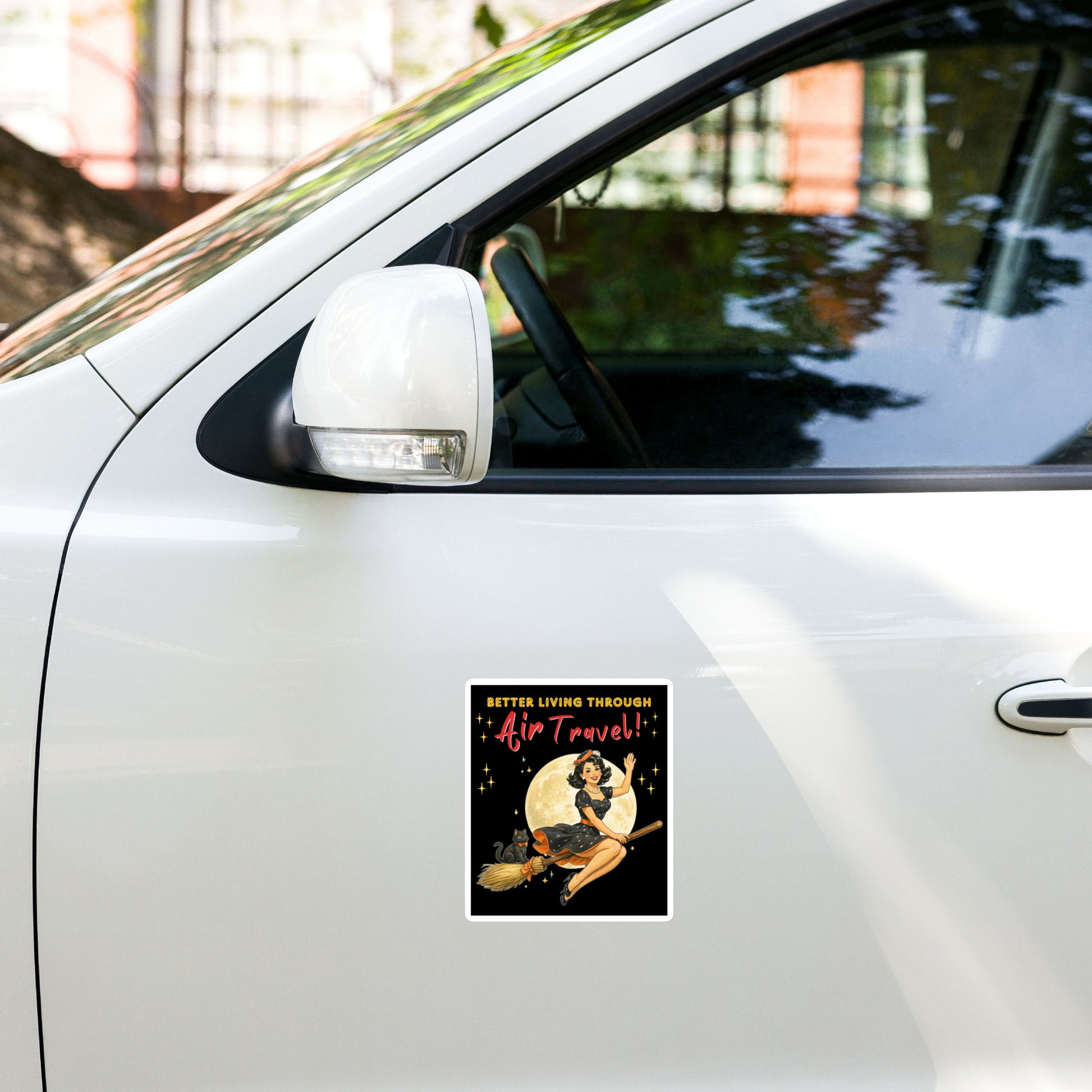 Better Living Through Air Travel vinyl decal — vintage retro pinup witch in black polka dot dress and stewardess hat riding a broom in front of a full moon with dapper black cat familiar in orange bow tie on black background, satin finish waterproof sticker by Cinderpoint Studios