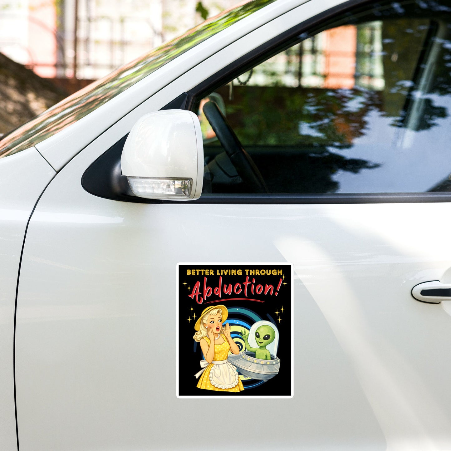 Better Living Through Abduction vinyl decal — vintage 1950s retro blonde housewife in yellow polka dot dress reacting with delight to a friendly green alien waving from a silver saucer on black background, satin finish waterproof sticker by Cinderpoint Studios