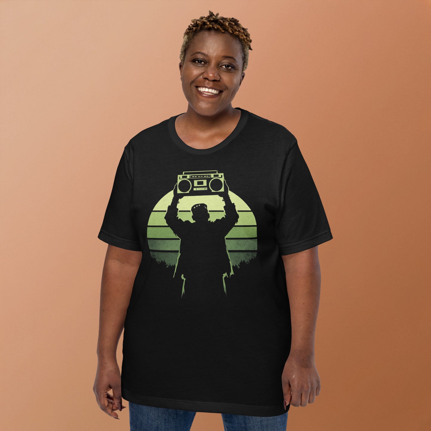 A retro-style graphic t-shirt featuring Frankenstein’s monster holding a 1980s boombox over his head in the iconic Say Anything movie pose, set against a vibrant neon sunburst.