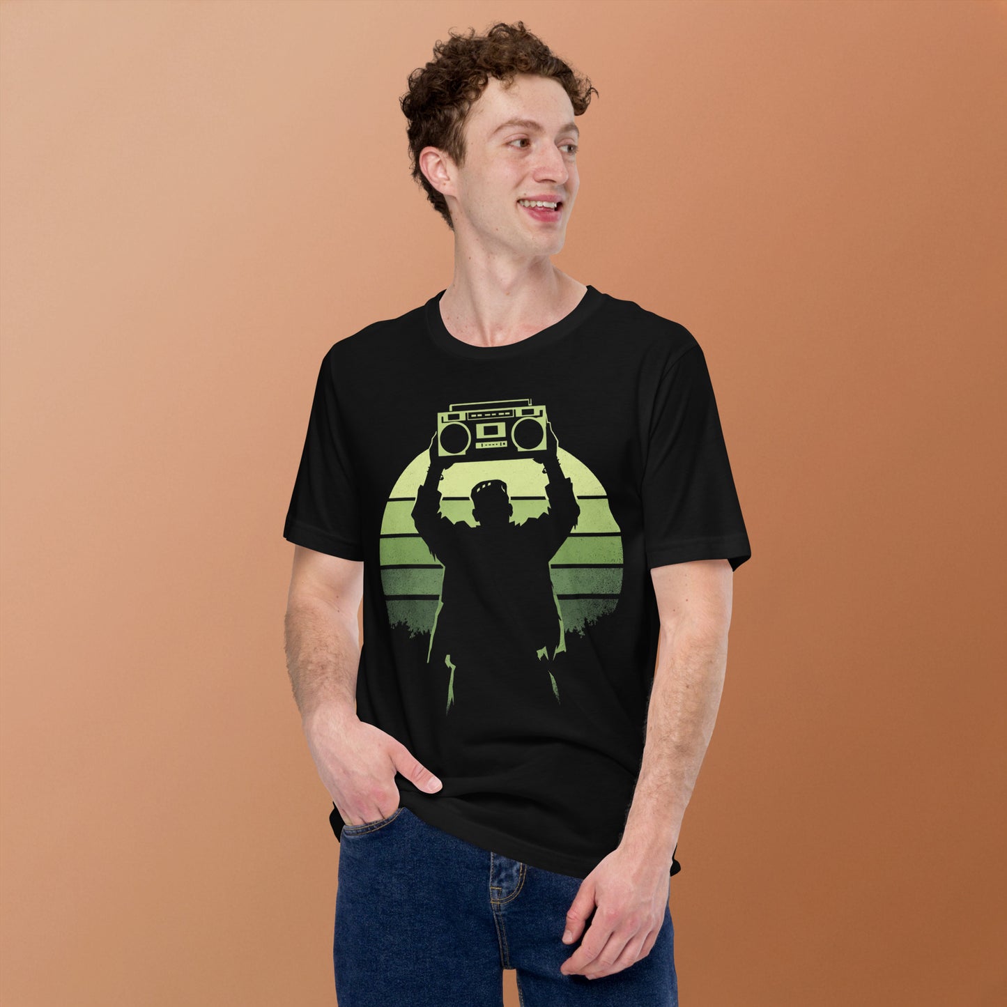 A retro-style graphic t-shirt featuring Frankenstein’s monster holding a 1980s boombox over his head in the iconic Say Anything movie pose, set against a vibrant neon sunburst.
