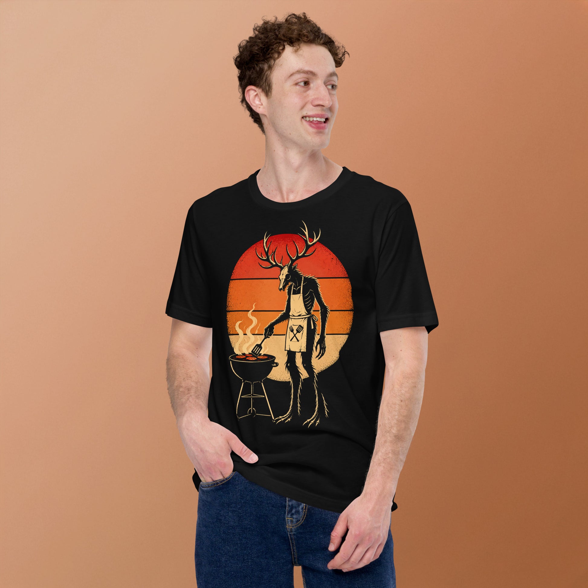 A retro-style graphic t-shirt featuring a Wendigo cryptid with antlers wearing a BBQ apron and grilling at a spatula, set against a vibrant 1980s neon sunset background.