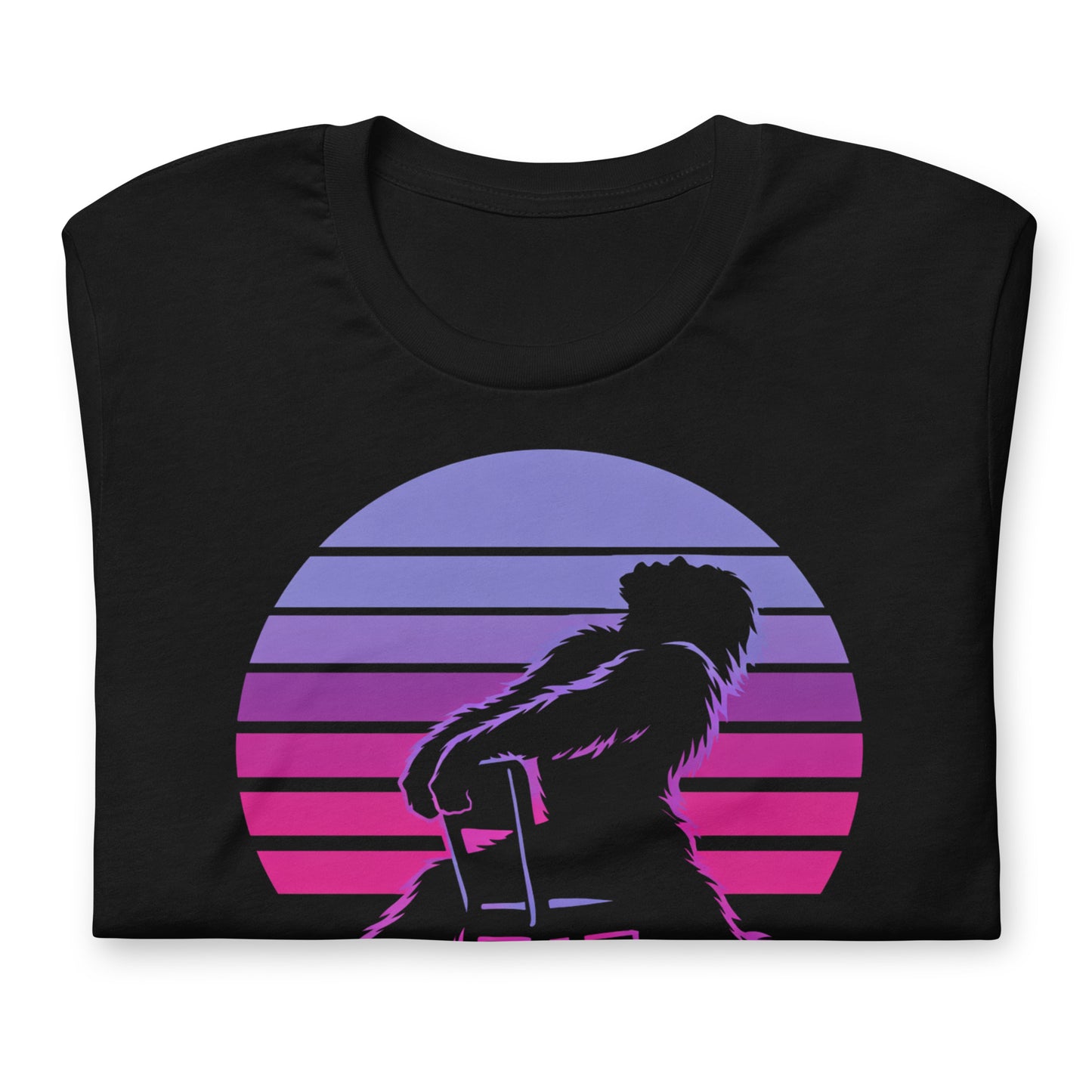 A retro graphic t-shirt featuring the cryptid Bigfoot in the iconic Flashdance chair-pose silhouette against a vibrant 1980s-style sunset.