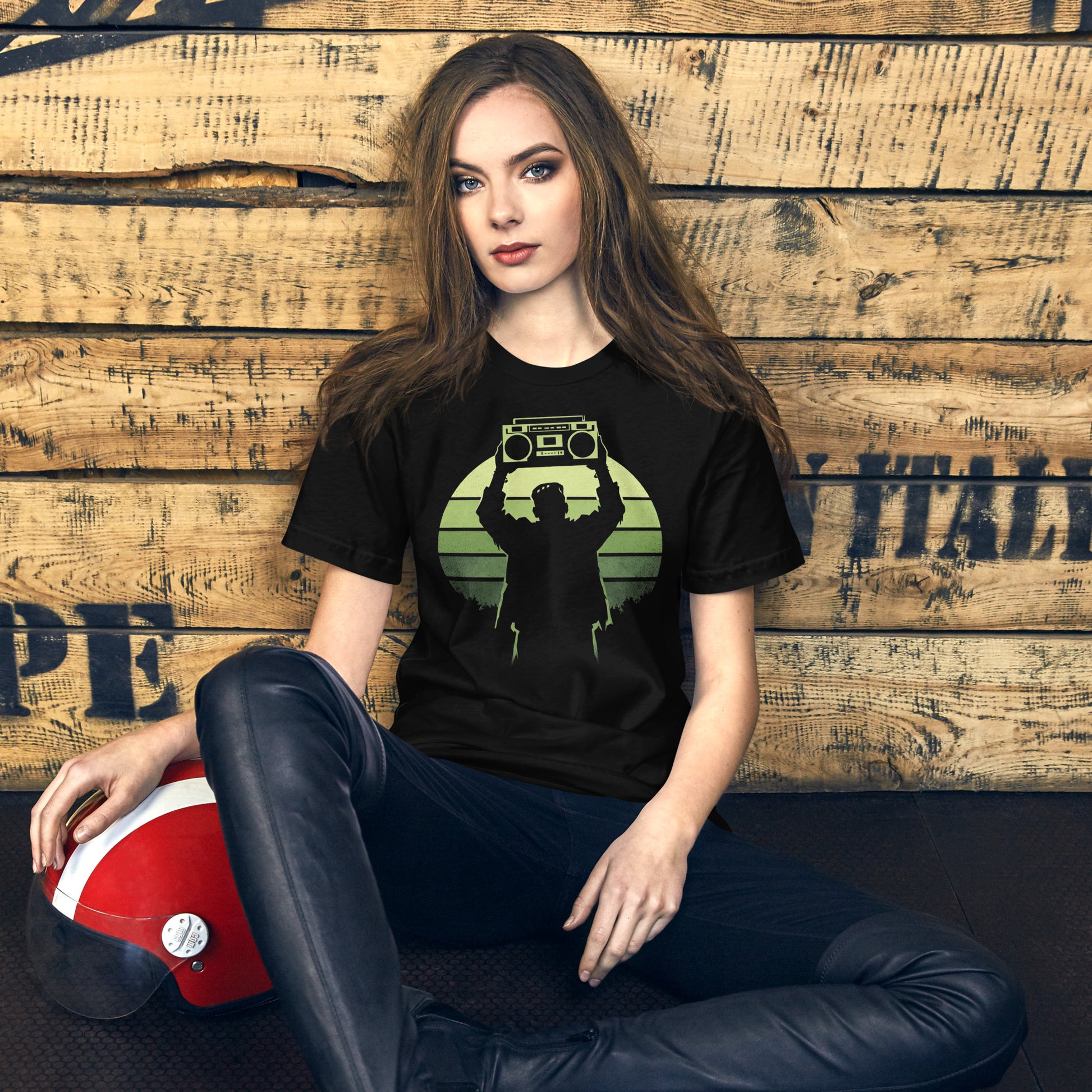 A retro-style graphic t-shirt featuring Frankenstein’s monster holding a 1980s boombox over his head in the iconic Say Anything movie pose, set against a vibrant neon sunburst.