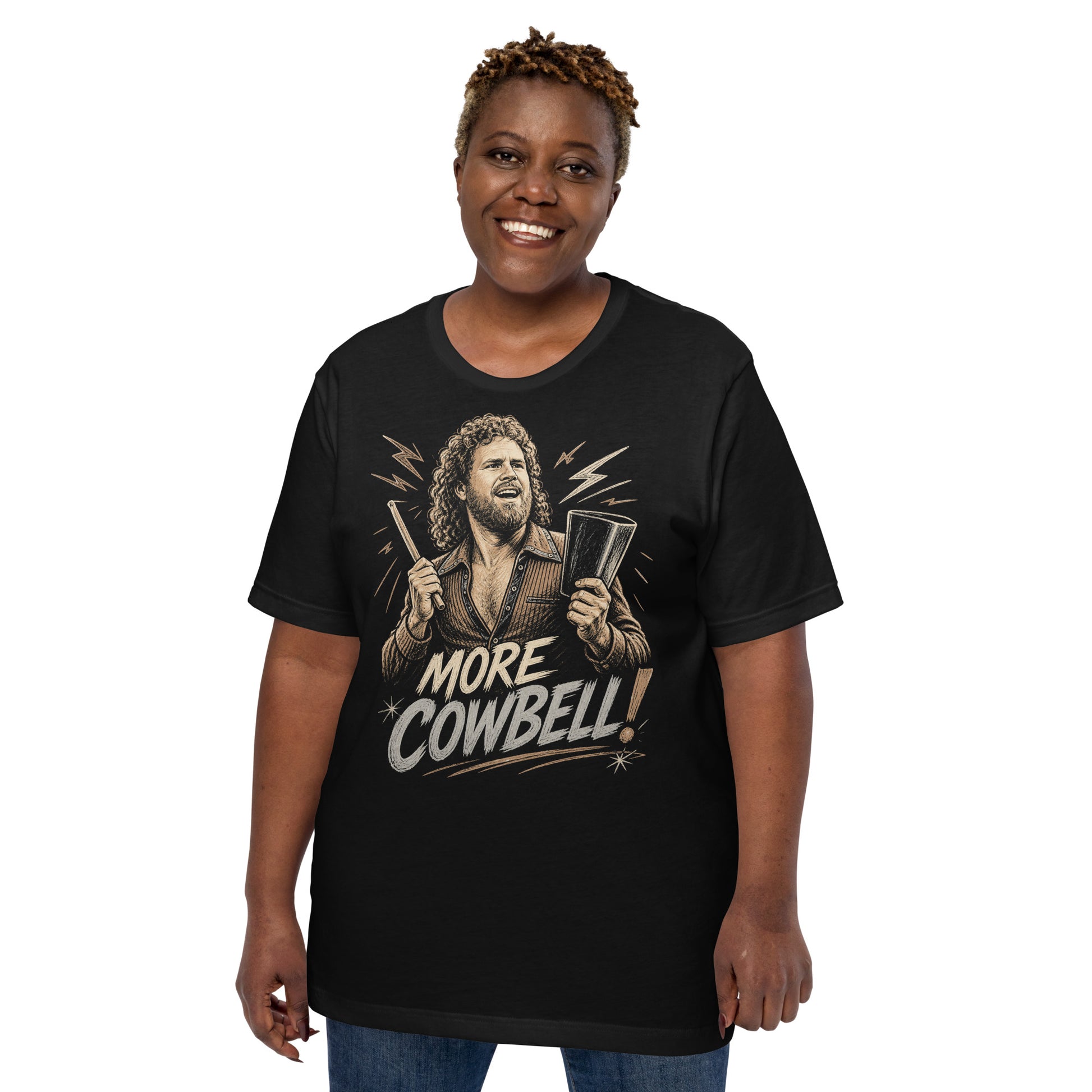 A gritty, woodcut-style illustration on a black t-shirt featuring a bearded man with curly hair and an open-collared 70s shirt holding a cowbell and drumstick, with the text 'MORE COWBELL!' in a distressed font.