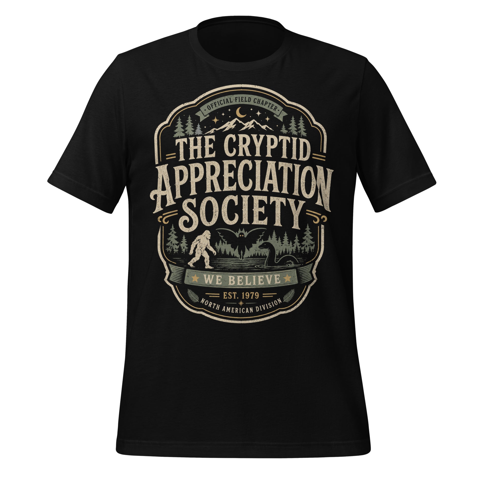 Black graphic tee featuring original Cinderpoint Studios artwork for The Cryptid Appreciation Society, a retro cryptid badge design with Sasquatch, Mothman, a Nessie-style lake creature, forest, mountains, moon, stars, and We Believe text.
