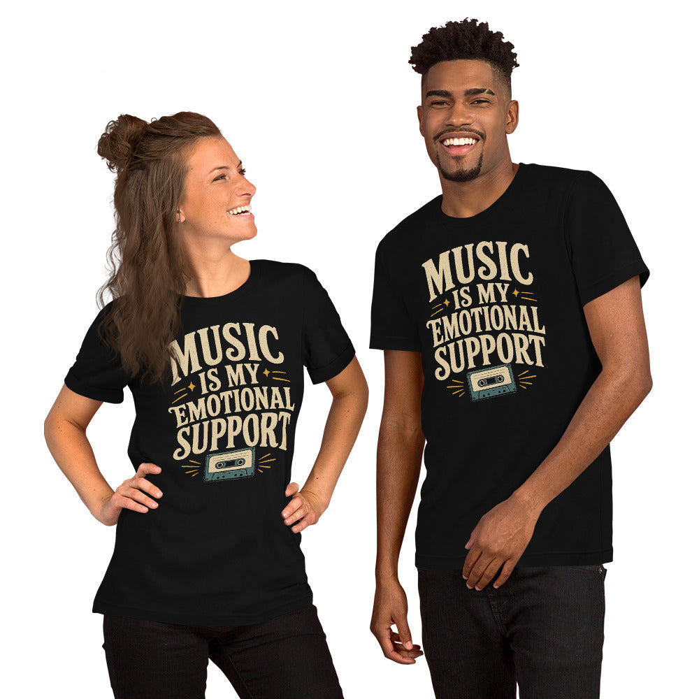A man and a woman wearing a black graphic tee with the Music Is My Emotional Support design by Cinderpoint Studios, featuring retro lettering, star accents, and a cassette tape graphic.
