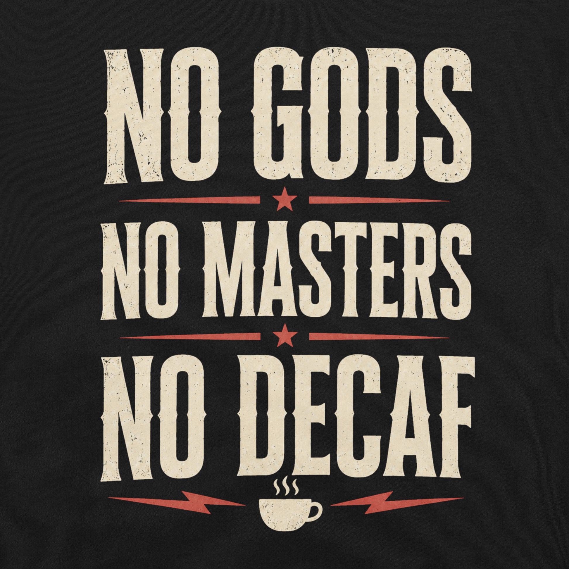 Close up of a black graphic tee featuring original Cinderpoint Studios artwork for No Gods No Masters No Decaf, a bold retro text design with cream lettering, red accent stars, lightning bolts, and a small coffee cup graphic.