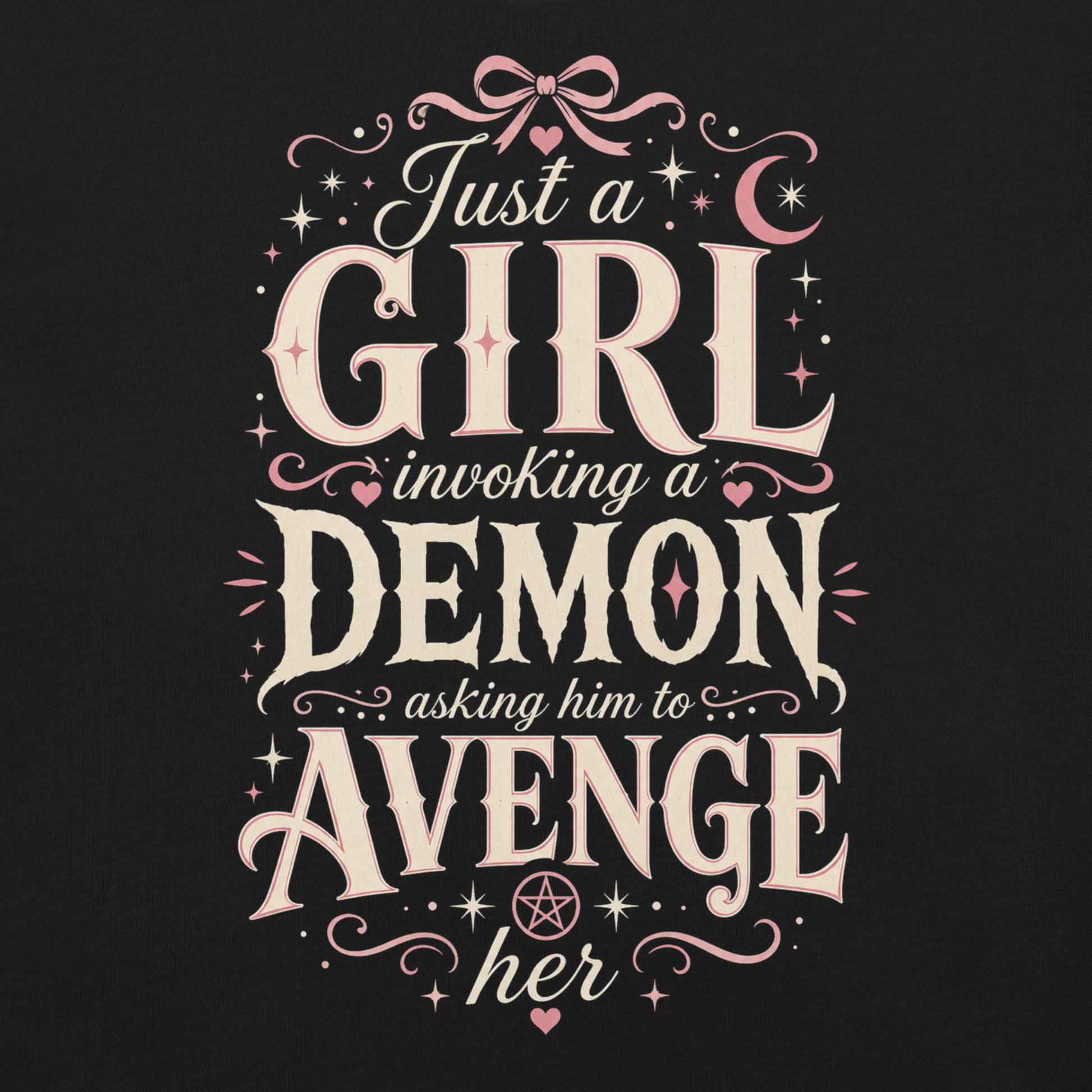 Black graphic tee featuring original Cinderpoint Studios artwork for Just a Girl Invoking a Demon, a feminine occult humor design with bold vintage lettering, pink bow accents, crescent moon, stars, hearts, and a small pentagram.