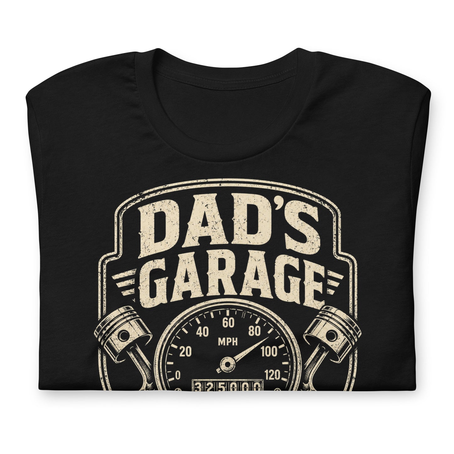 A black graphic tee featuring original Cinderpoint Studios artwork for Dad’s Garage, a one-color retro garage badge design with bold lettering, a speedometer, pistons, spark plug, wrench, and High Mileage Low Tolerance text.