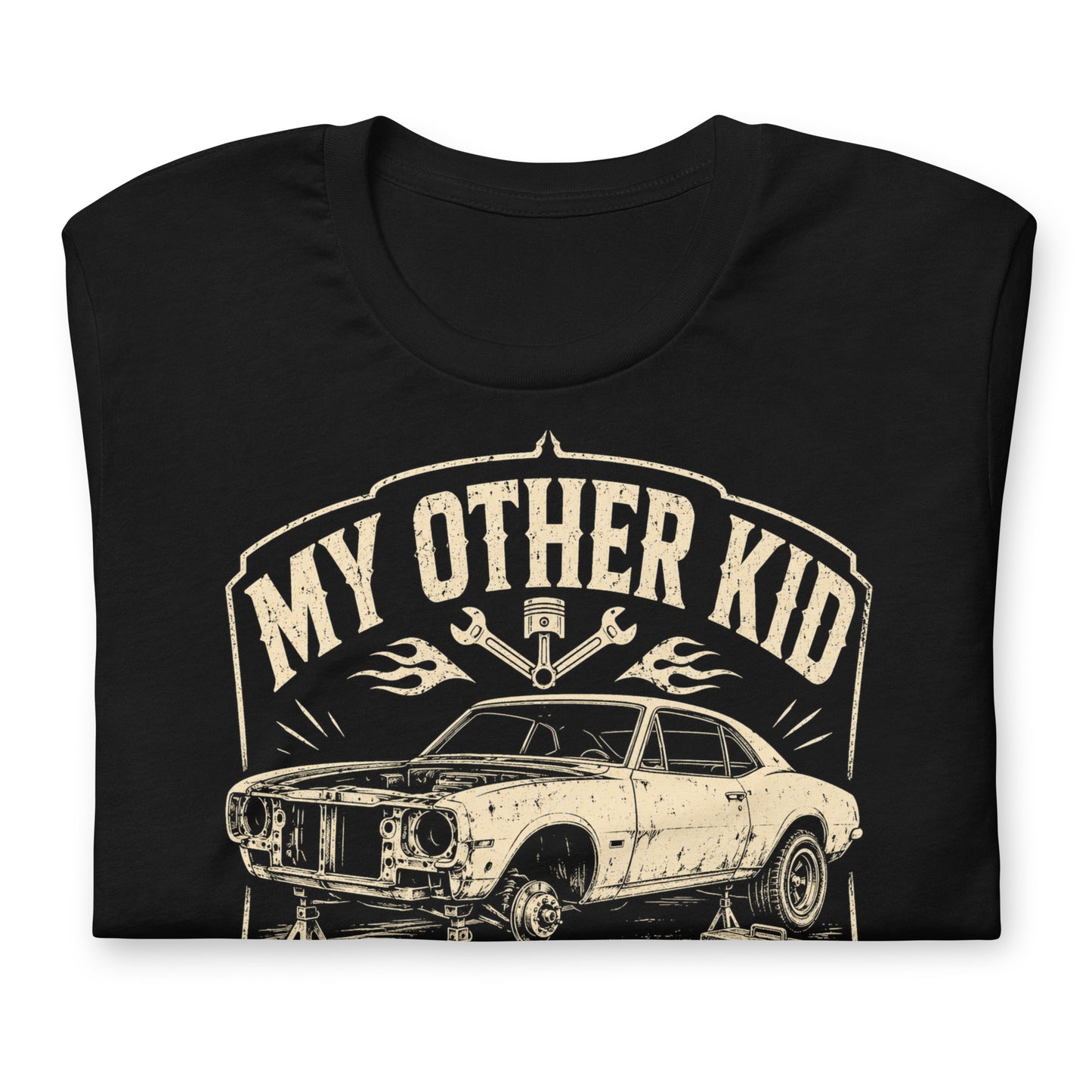 A black graphic tee featuring original Cinderpoint Studios artwork for My Other Kid Is a Project Car, a one-color retro garage design with a classic project car on jack stands, tools, piston and wrench accents, flames, and bold vintage lettering.