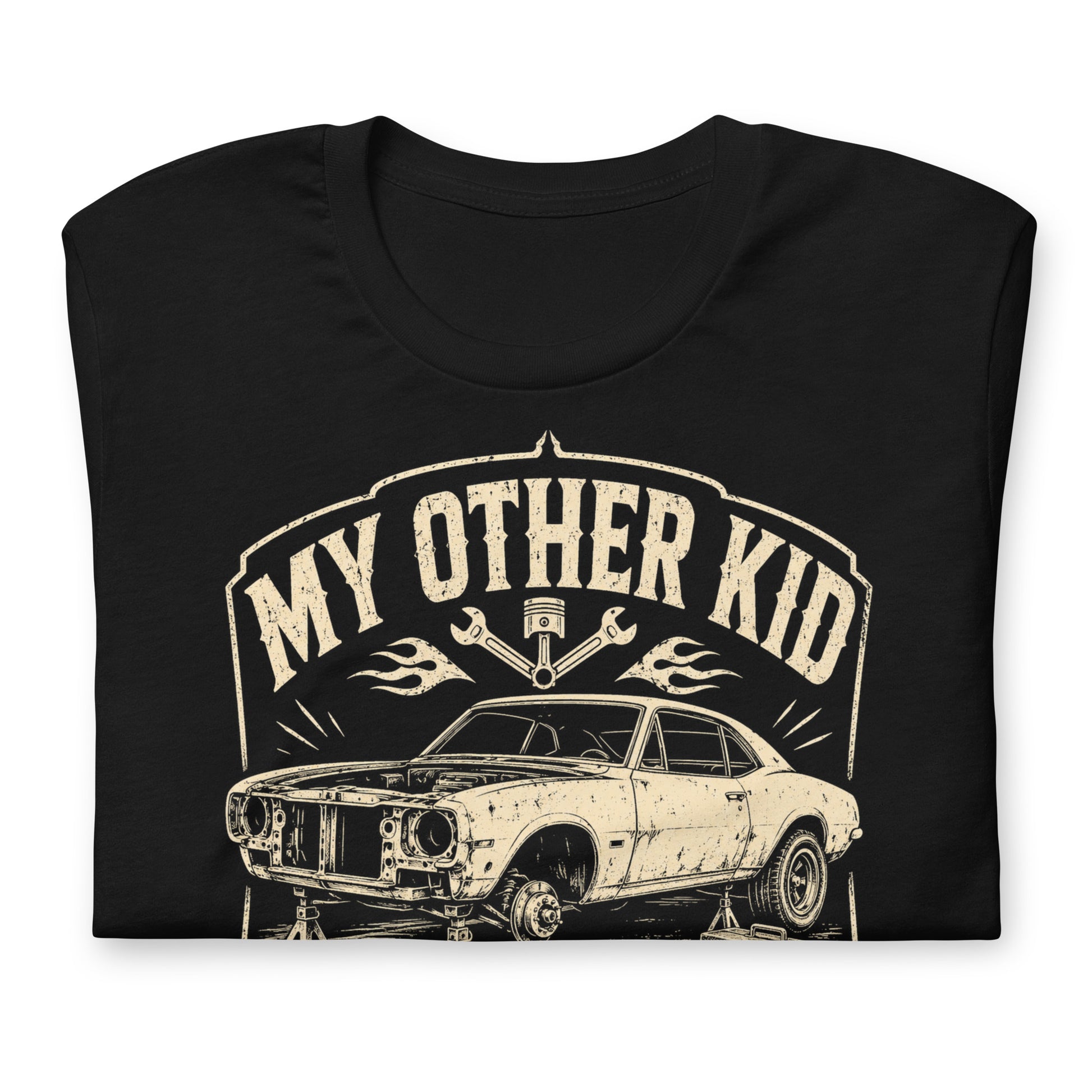 A black graphic tee featuring original Cinderpoint Studios artwork for My Other Kid Is a Project Car, a one-color retro garage design with a classic project car on jack stands, tools, piston and wrench accents, flames, and bold vintage lettering.
