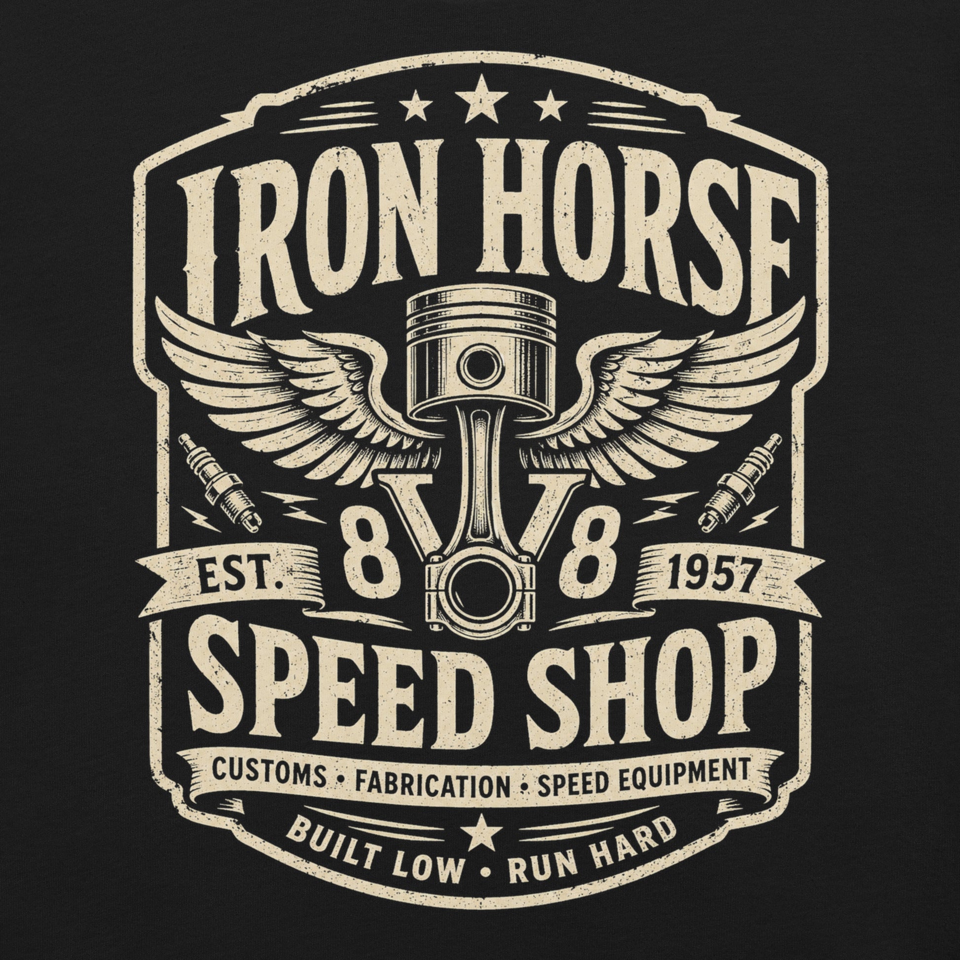 A black graphic tee featuring original Cinderpoint Studios artwork for Iron Horse Speed Shop, a one-color retro garage badge design with winged piston artwork, spark plugs, stars, banner details, V8 text, and Built Low Run Hard lettering.