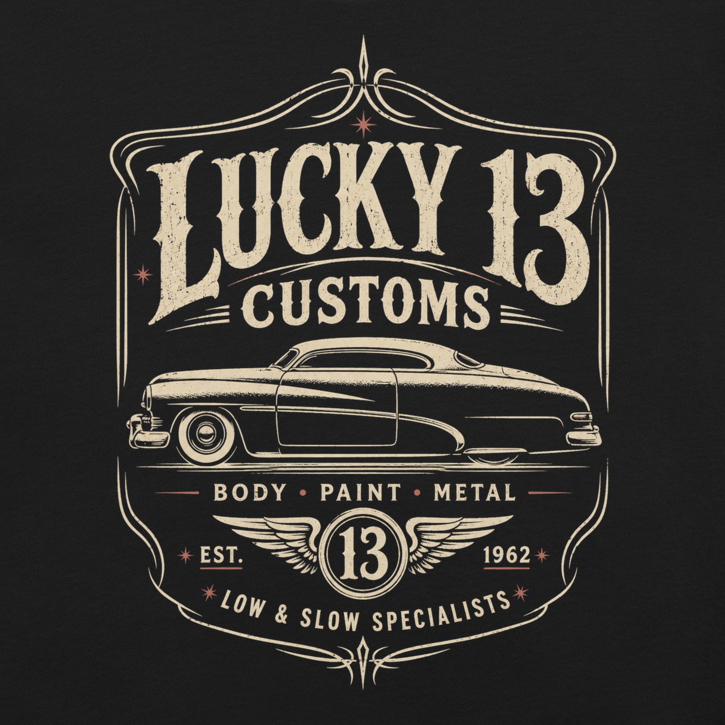 A black graphic tee featuring original Cinderpoint Studios artwork for Lucky 13 Customs, a retro custom shop design with a lowrider-style classic car, bold vintage lettering, winged 13 emblem, pinstripe-style frame, and Low & Slow Specialists text.