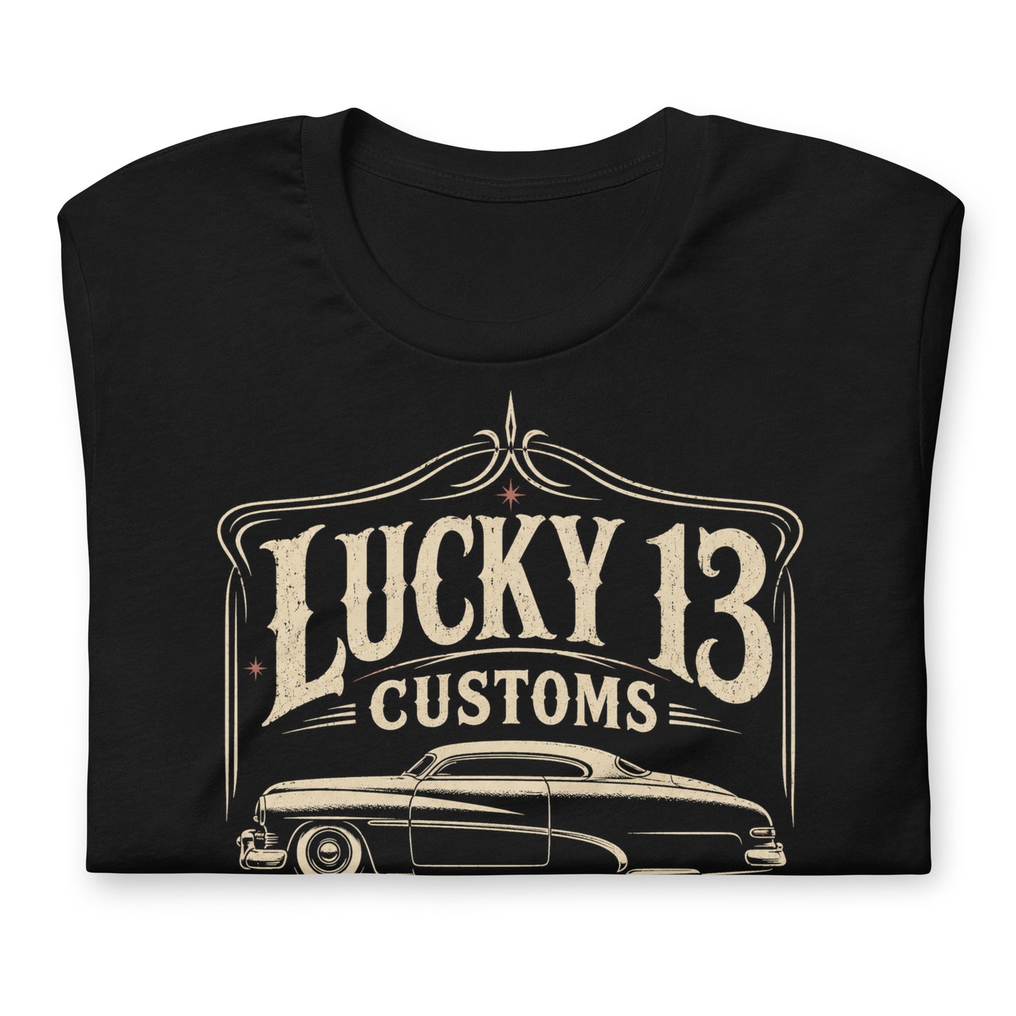 A black graphic tee featuring original Cinderpoint Studios artwork for Lucky 13 Customs, a retro custom shop design with a lowrider-style classic car, bold vintage lettering, winged 13 emblem, pinstripe-style frame, and Low & Slow Specialists text.