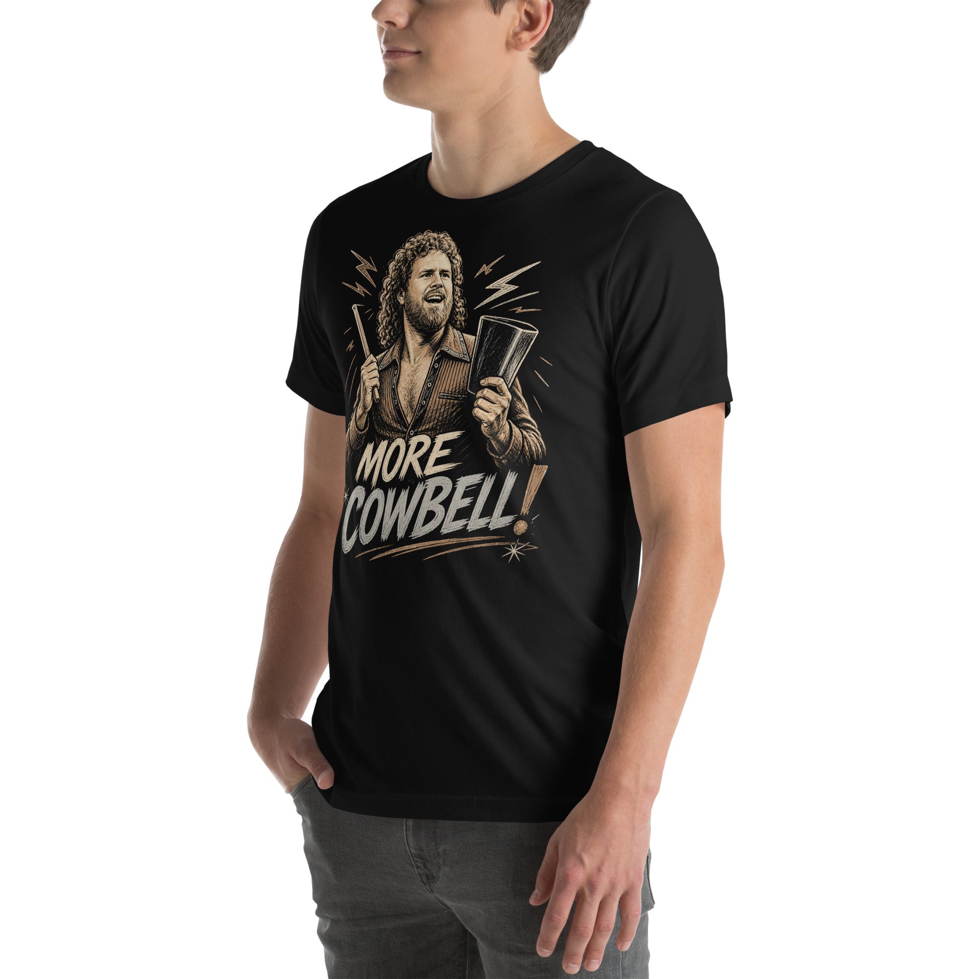 A gritty, woodcut-style illustration on a black t-shirt featuring a bearded man with curly hair and an open-collared 70s shirt holding a cowbell and drumstick, with the text 'MORE COWBELL!' in a distressed font.