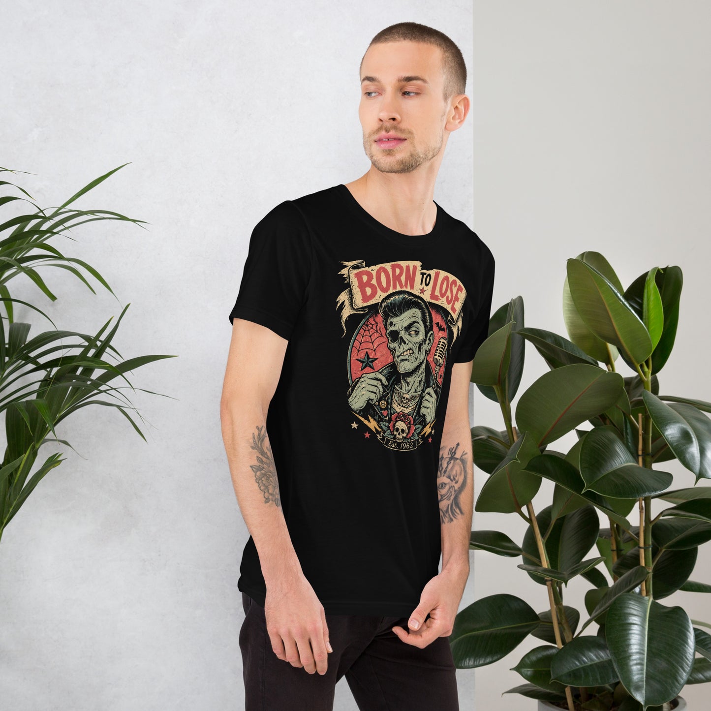 Young man wearing A vintage tattoo flash-style graphic on a black t-shirt featuring a green-skinned zombie monster with a banner that says "Born to Lose"