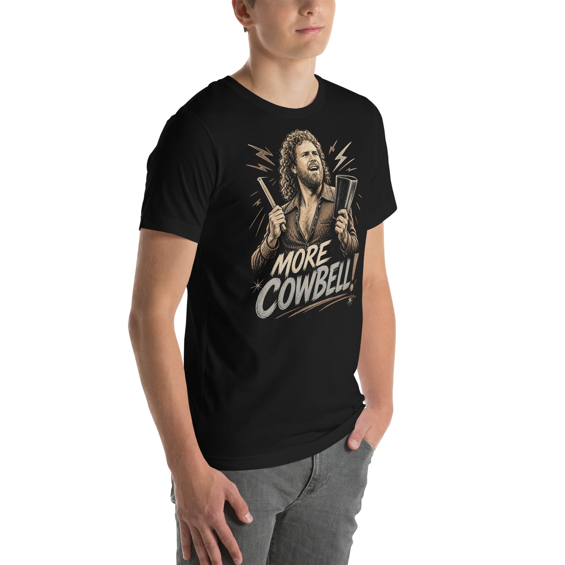 A gritty, woodcut-style illustration on a black t-shirt featuring a bearded man with curly hair and an open-collared 70s shirt holding a cowbell and drumstick, with the text 'MORE COWBELL!' in a distressed font.