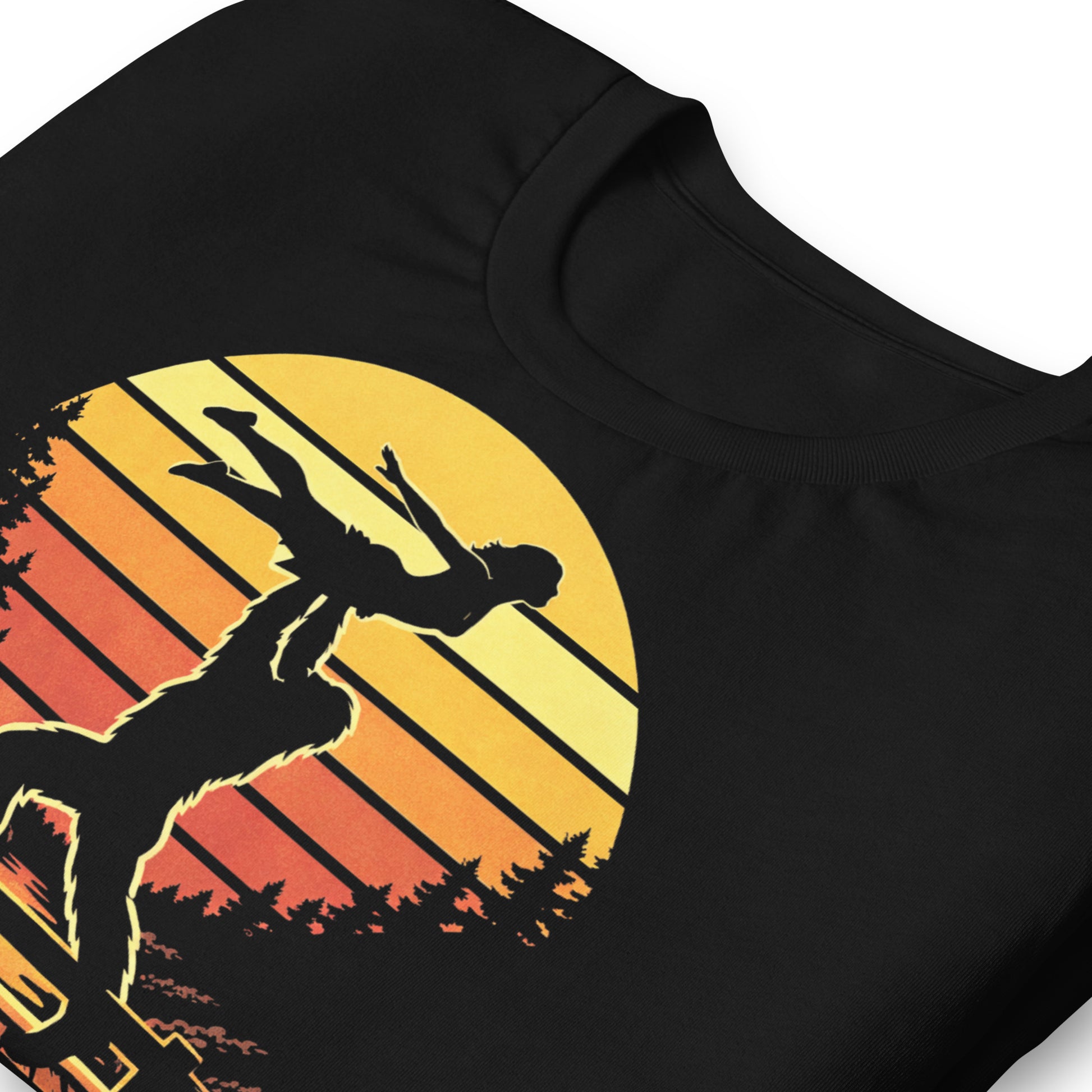 A retro-style graphic t-shirt featuring the cryptid Bigfoot performing the iconic Dirty Dancing lift pose against a vibrant, multi-colored 80s sunburst background.