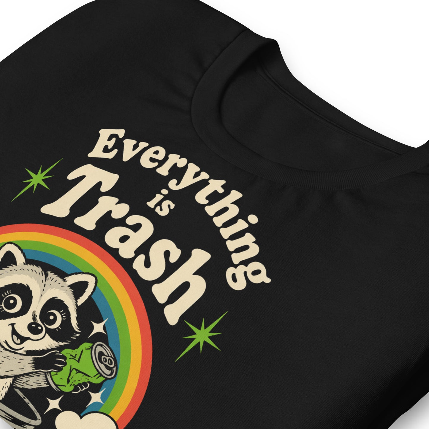 A retro 1970s-style graphic t-shirt featuring a cute raccoon sitting under a vibrant rainbow with the text "Everything Is Trash" in vintage-inspired lettering