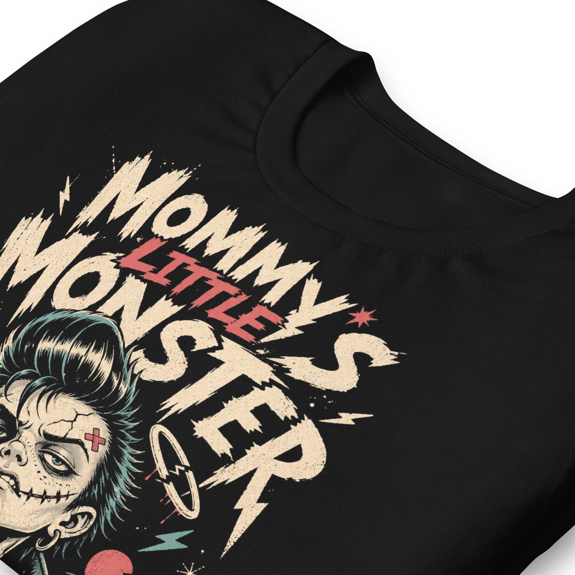 A retro lowbrow-style graphic on a black t-shirt featuring a green-skinned monster child with a black pompadour, stitched facial details, and leather jacket.