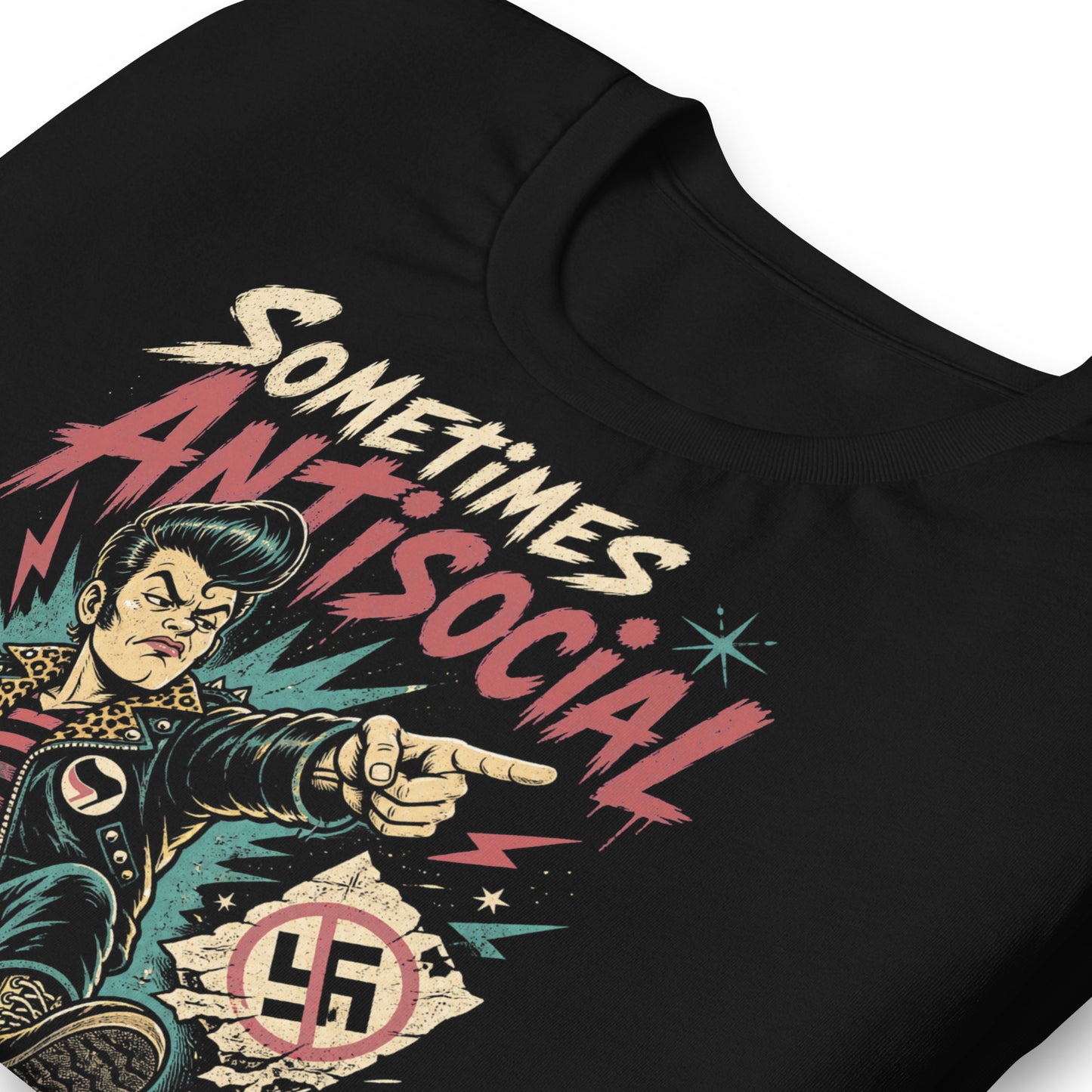 A gritty, lowbrow illustration on a black t-shirt of a pompadoured greaser in a leopard-print lined leather jacket, kicking over hate symbols. Text reads 'Sometimes Antisocial Always Antifascist' in a distressed punk-style font.