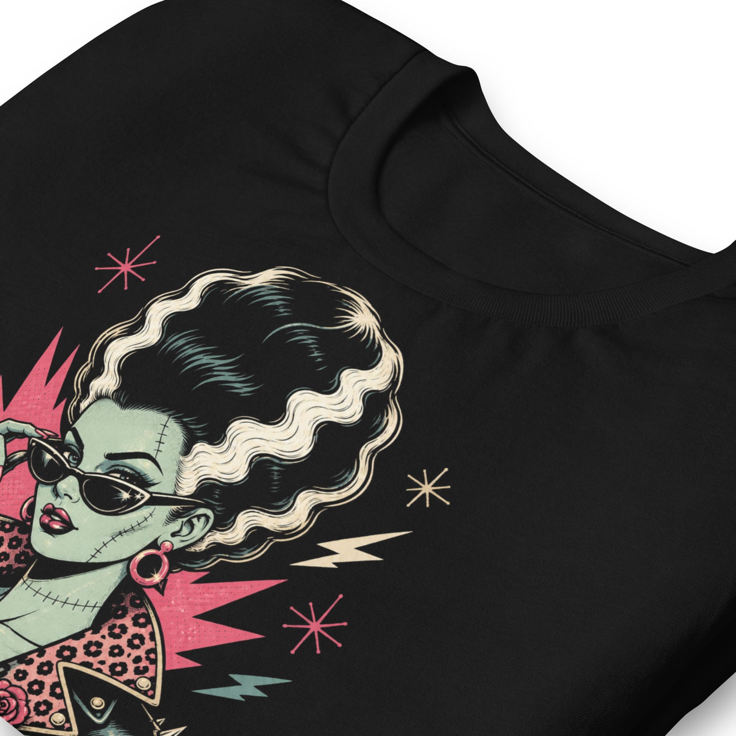 Artistic illustration of a green-skinned monster bride with high-volume black and white hair, cat-eye sunglasses, and a leopard-print lined leather jacket on a black t-shirt.