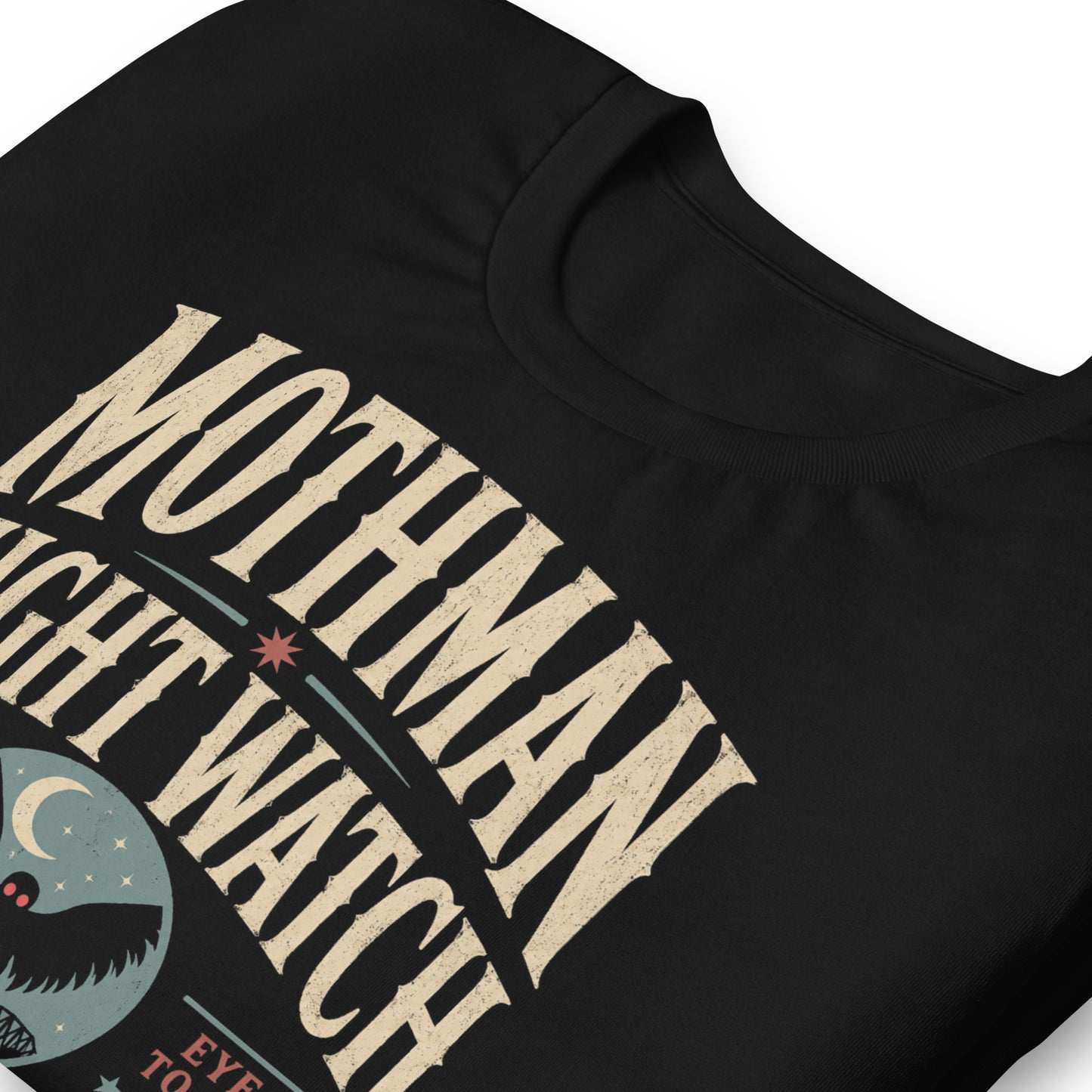 Close-up of the Mothman Night Watch original Cinderpoint Studios artwork printed on a black tee, showing distressed retro lettering, Mothman silhouette with red eyes, crescent moon, bridge scene, and Winged Incident Unit text.