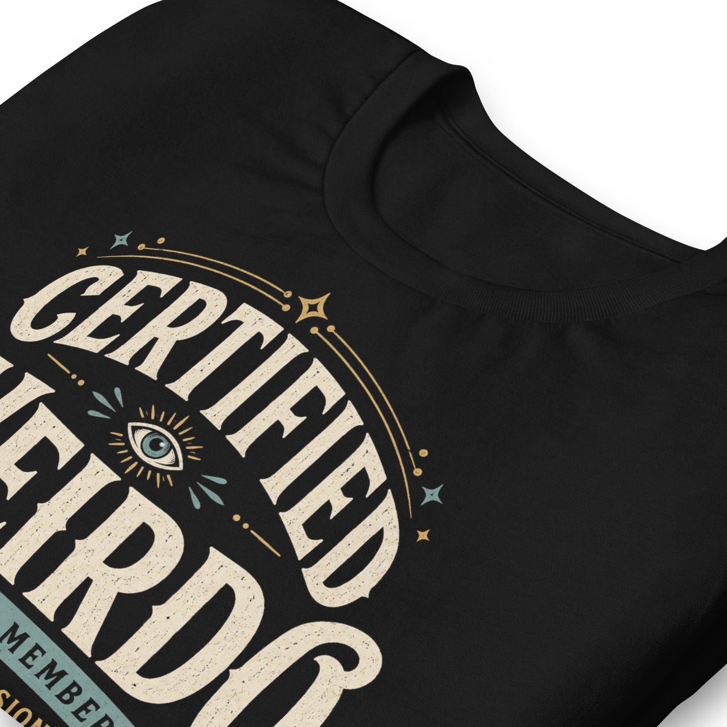 Close-up of the Certified Weirdo original Cinderpoint Studios artwork printed on a black tee, showing distressed retro lettering, all-seeing eye illustration, stars, banner details, and No Further Testing Required text.