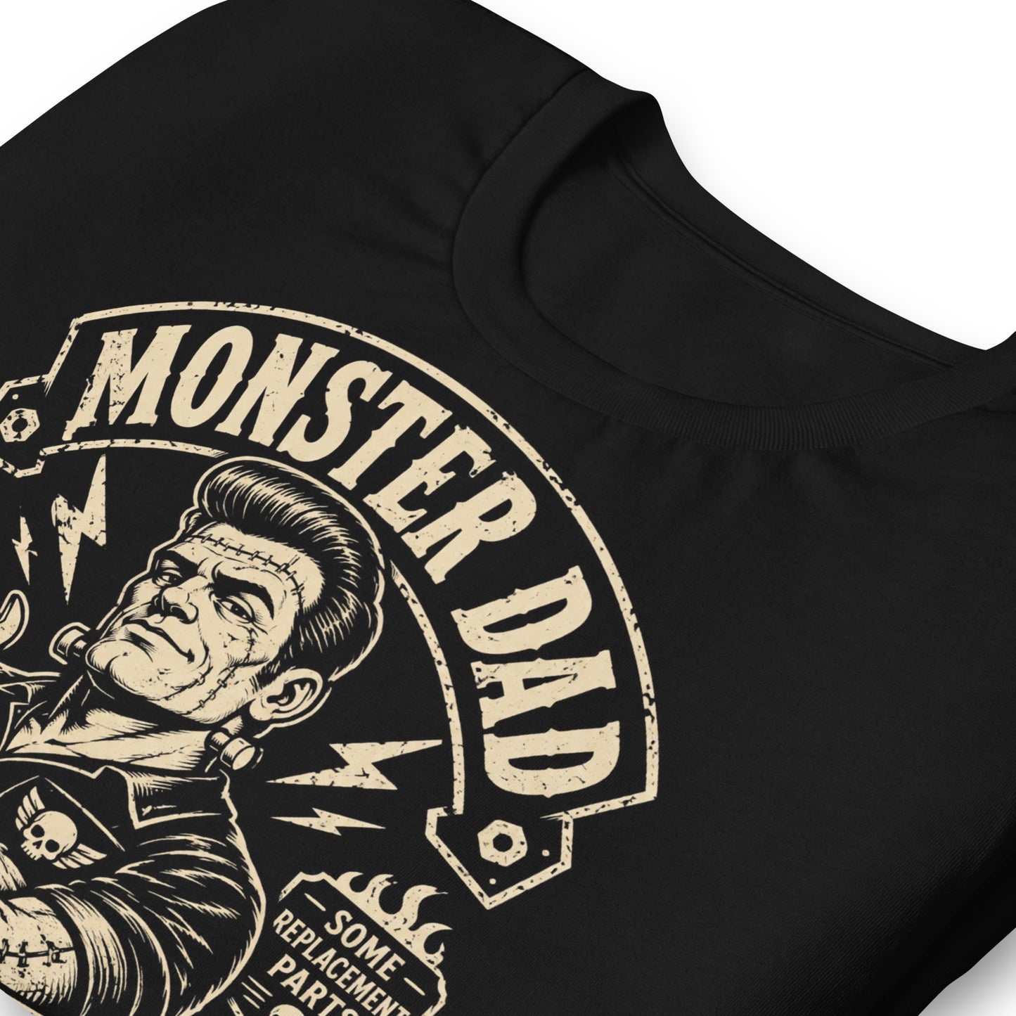 A black graphic tee featuring original Cinderpoint Studios artwork for Monster Dad Motor Club, a one-color retro garage design with a Frankenstein-inspired dad mechanic holding a wrench, lightning bolts, flames, skull details, piston accents, and text including Classic Model and Some Replacement Parts.
