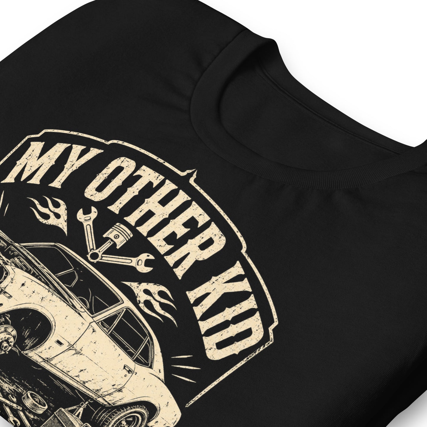 A black graphic tee featuring original Cinderpoint Studios artwork for My Other Kid Is a Project Car, a one-color retro garage design with a classic project car on jack stands, tools, piston and wrench accents, flames, and bold vintage lettering.